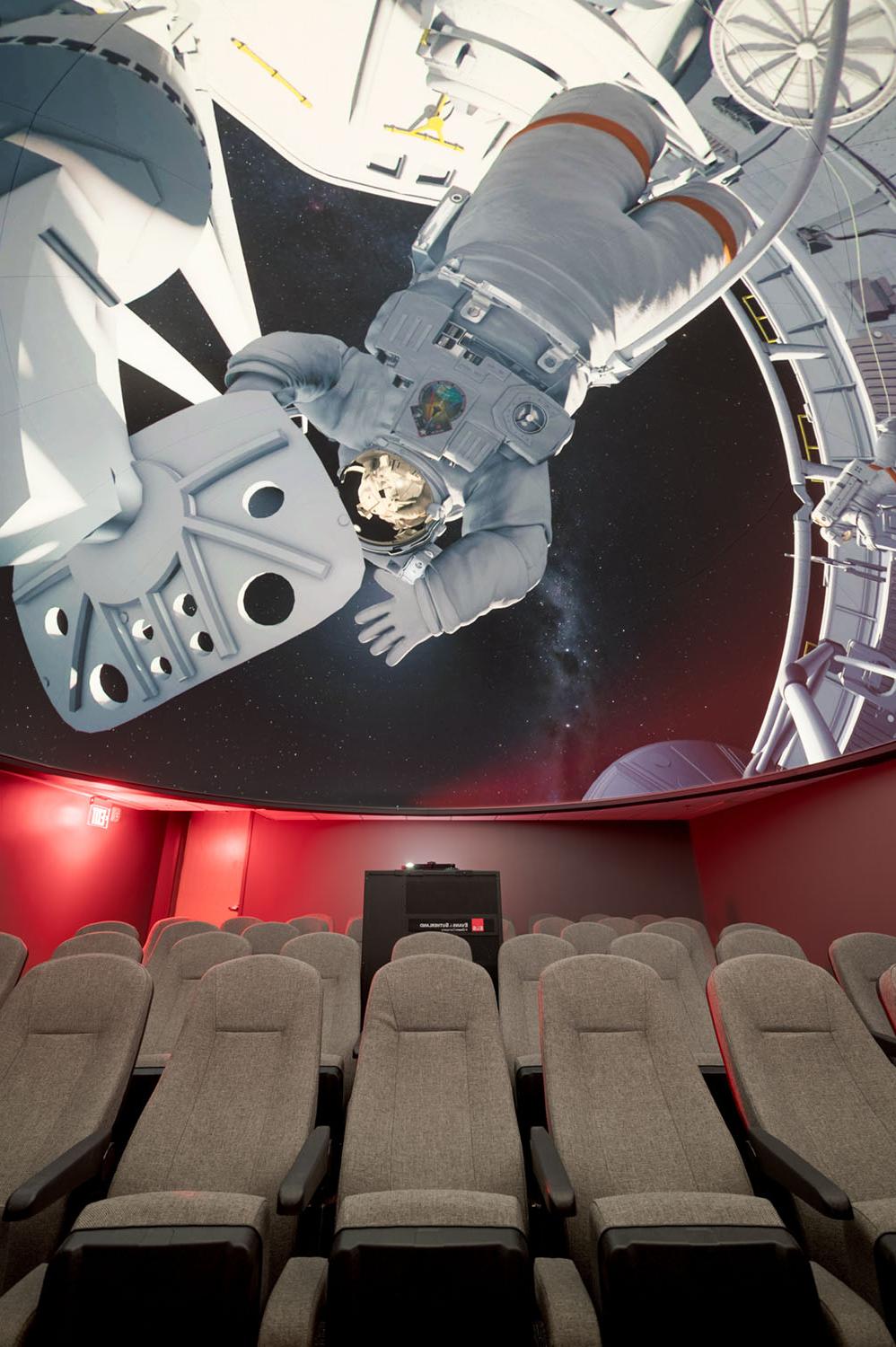 Planetarium seating and dome with spacewalk image on screen